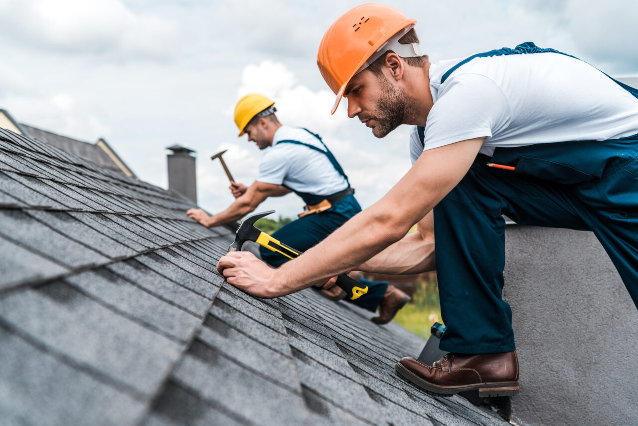 Two roofers working on a pitched roof