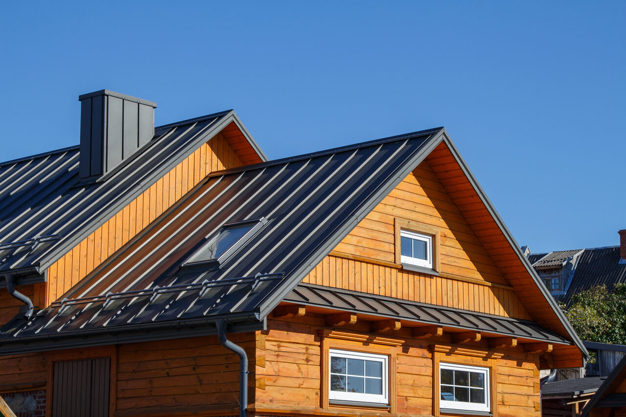 Black standing seam metal roof on a timber home