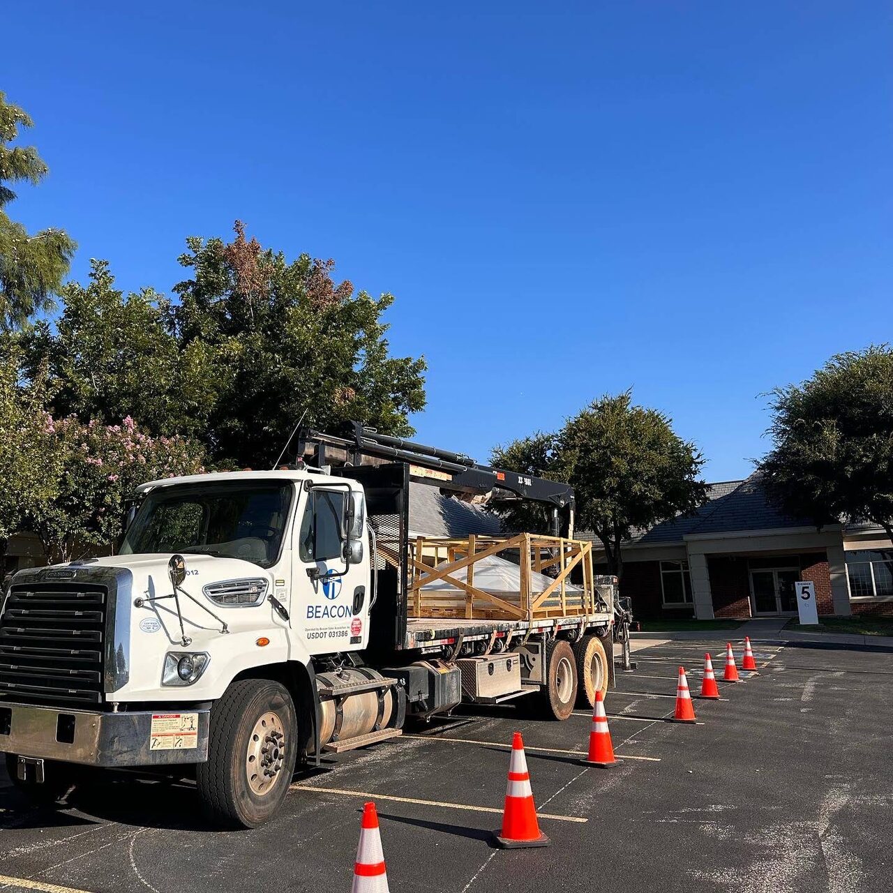 A Champion Roofing materials delivery truck at a coned off Oklahoma City job site