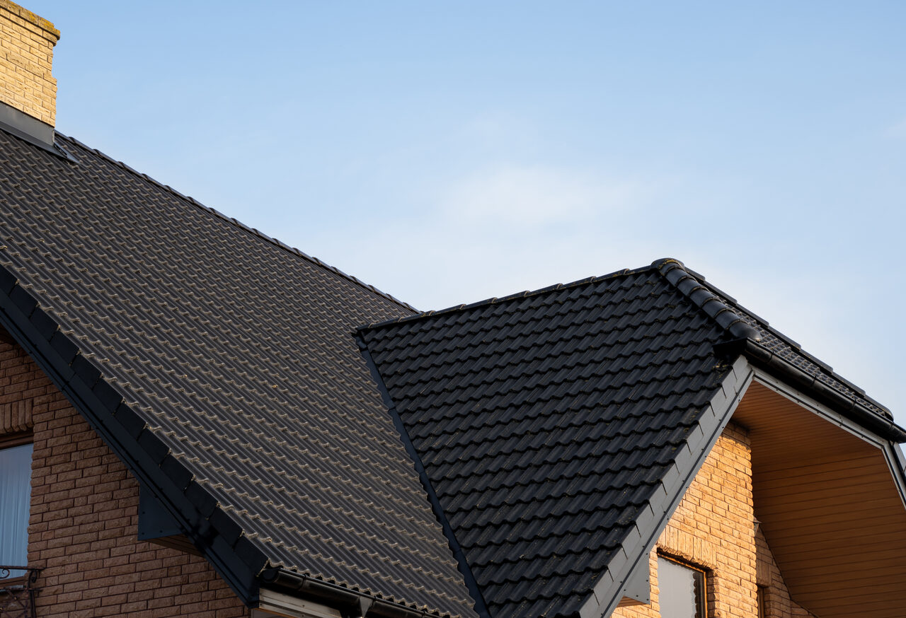 A brick home with a dark tile roof