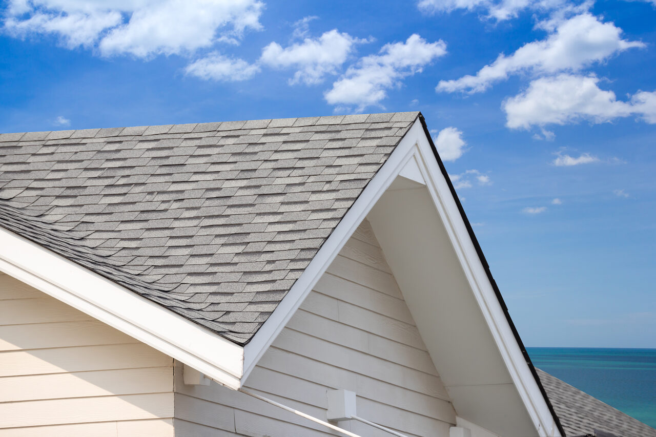 A residential roof gable against a clear blue sky