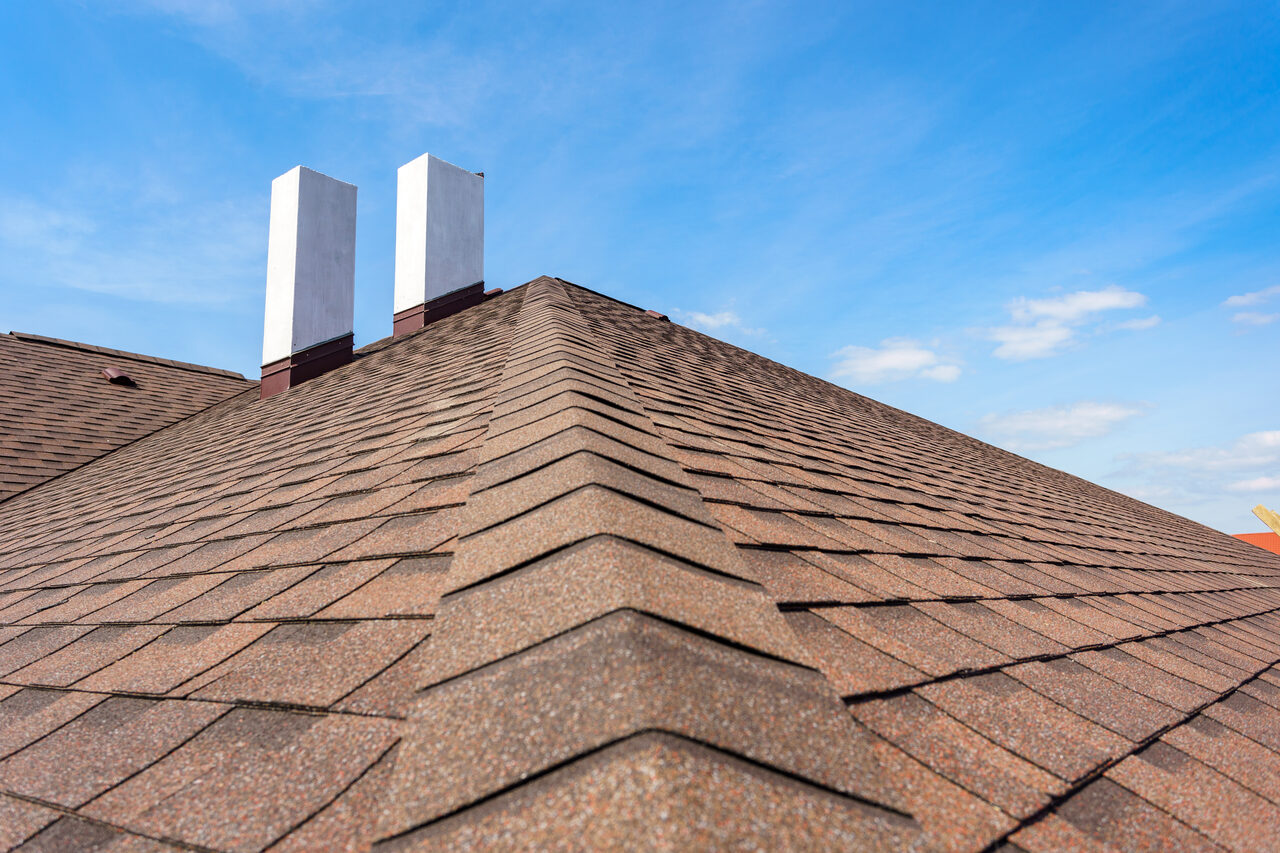 Architectural asphalt shingle roof with brick chimneys