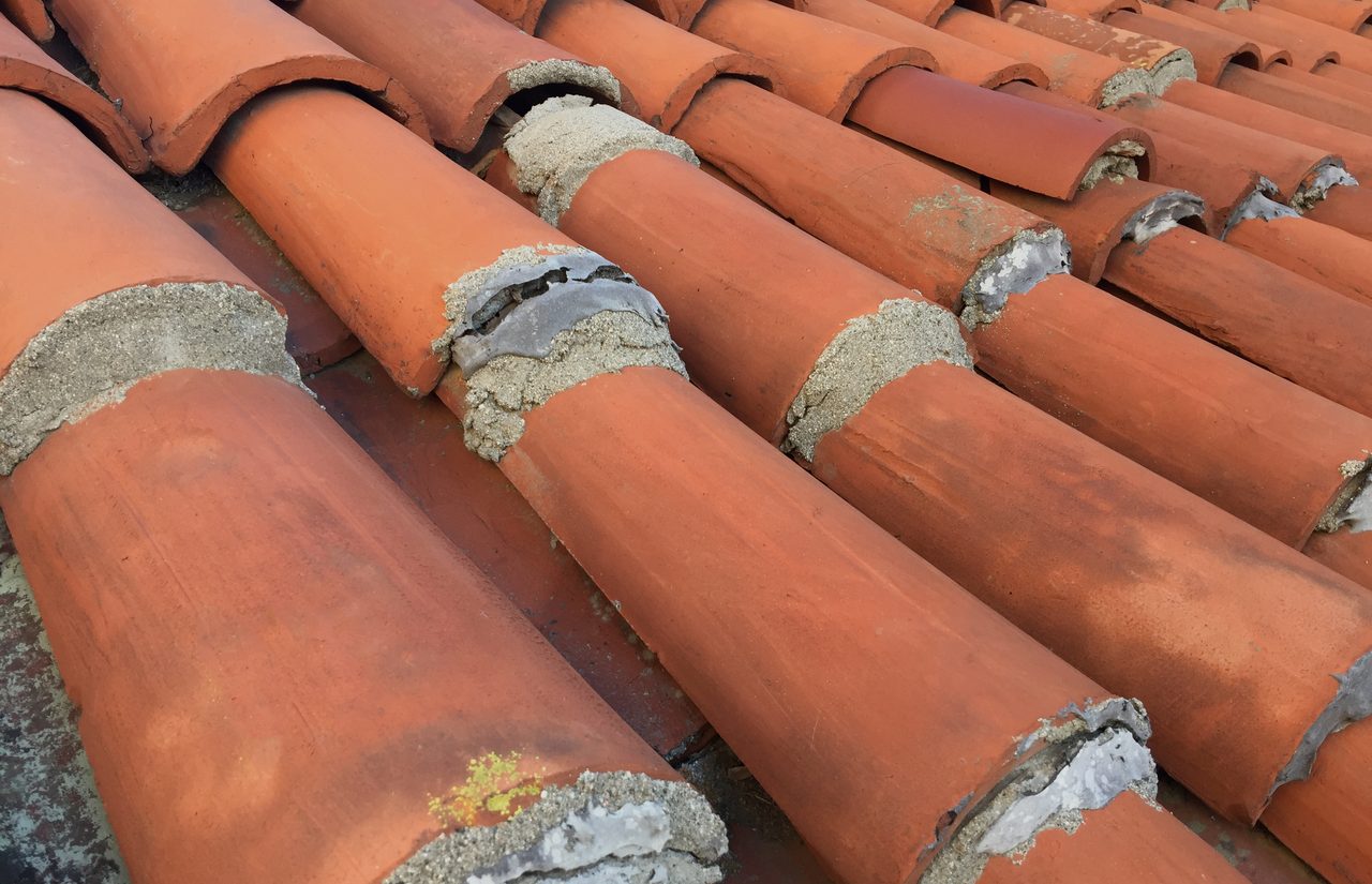 Weathered clay barrel tiles bedded in mortar, a few joints patched
