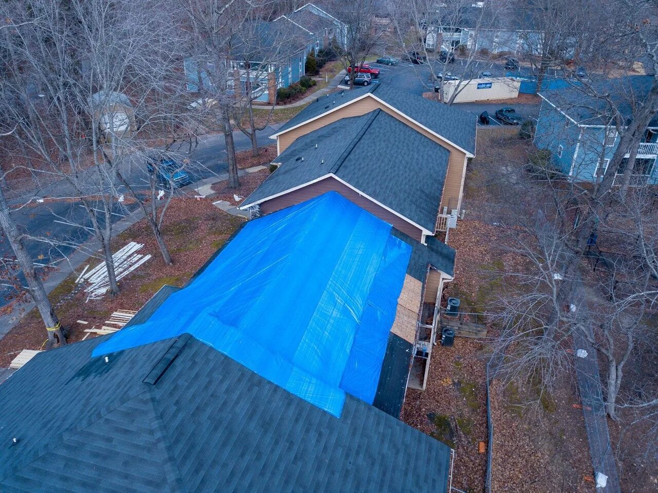 Aerial view of a tarp over a storm damaged roof